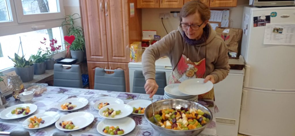 Podopieczna nakłada porcje obiadowe na talerze