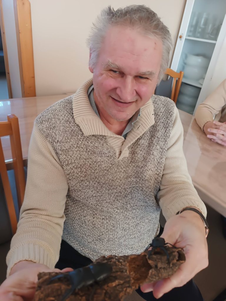 Podopieczny trzyma gałązkę na której siedzi chrząszcz