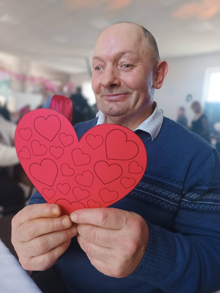 Podopieczny trzyma w dłoniach serce z papieru