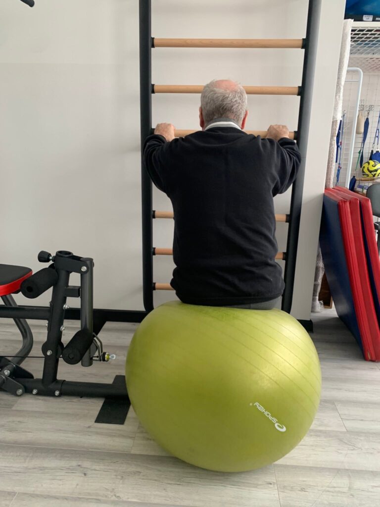 podopieczny ćwiczy na piłce rehabilitacyjnej