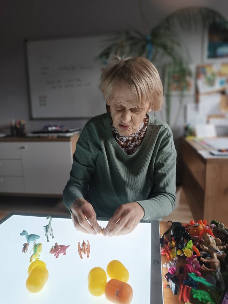 Podopieczna układa figurki dinozaurów