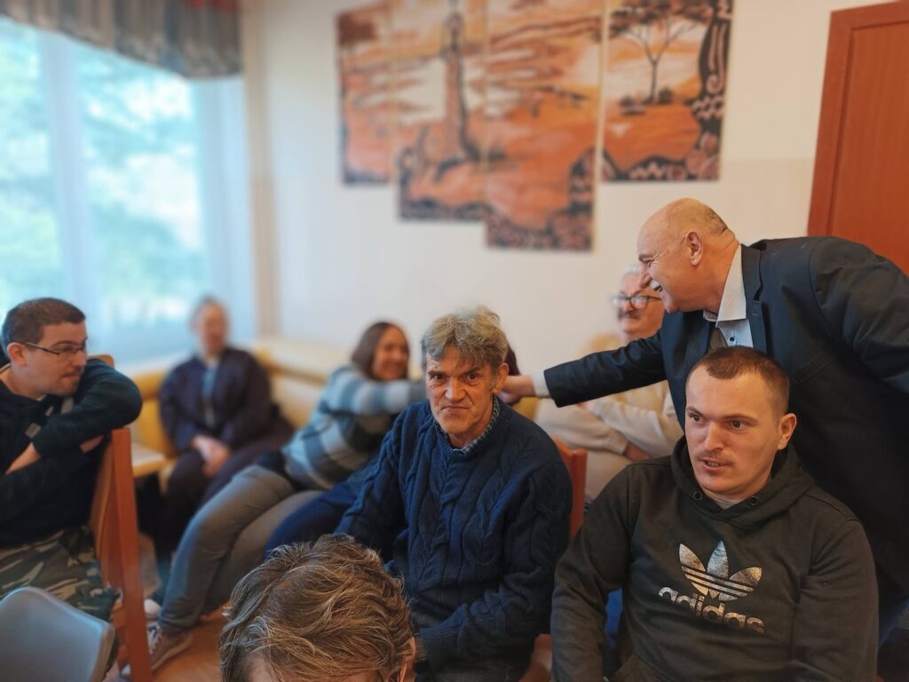 Artysta wita się z podopiecznymi obecnymi na spotkaniu