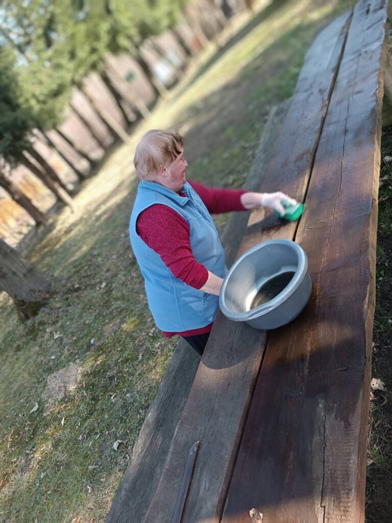 Podopieczna myje meble ogrodowe