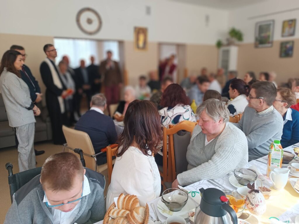 Ksiądz odmawia modlitwę przed wspólnym posiłkiem