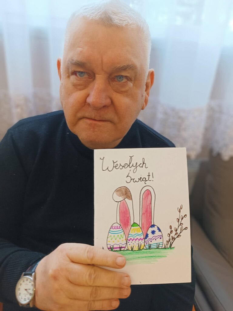 Podopieczny trzyma w ręce kartkę świąteczną