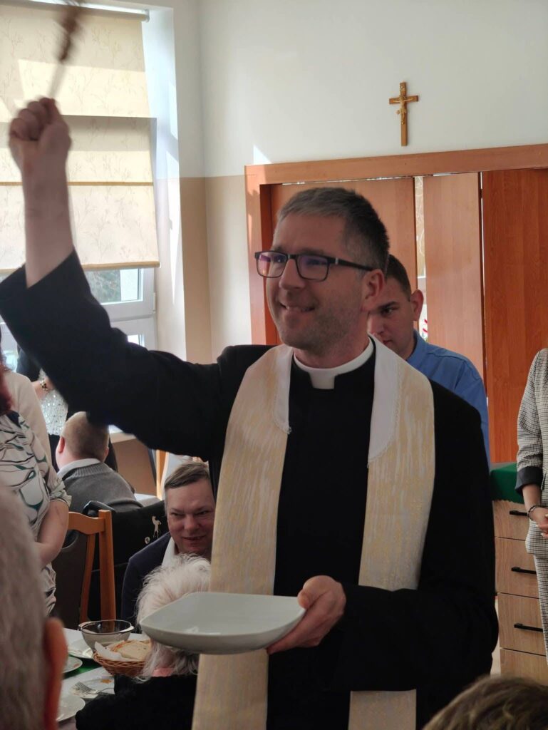 ksiądz święci pokarmy i zgromadzonych gości
