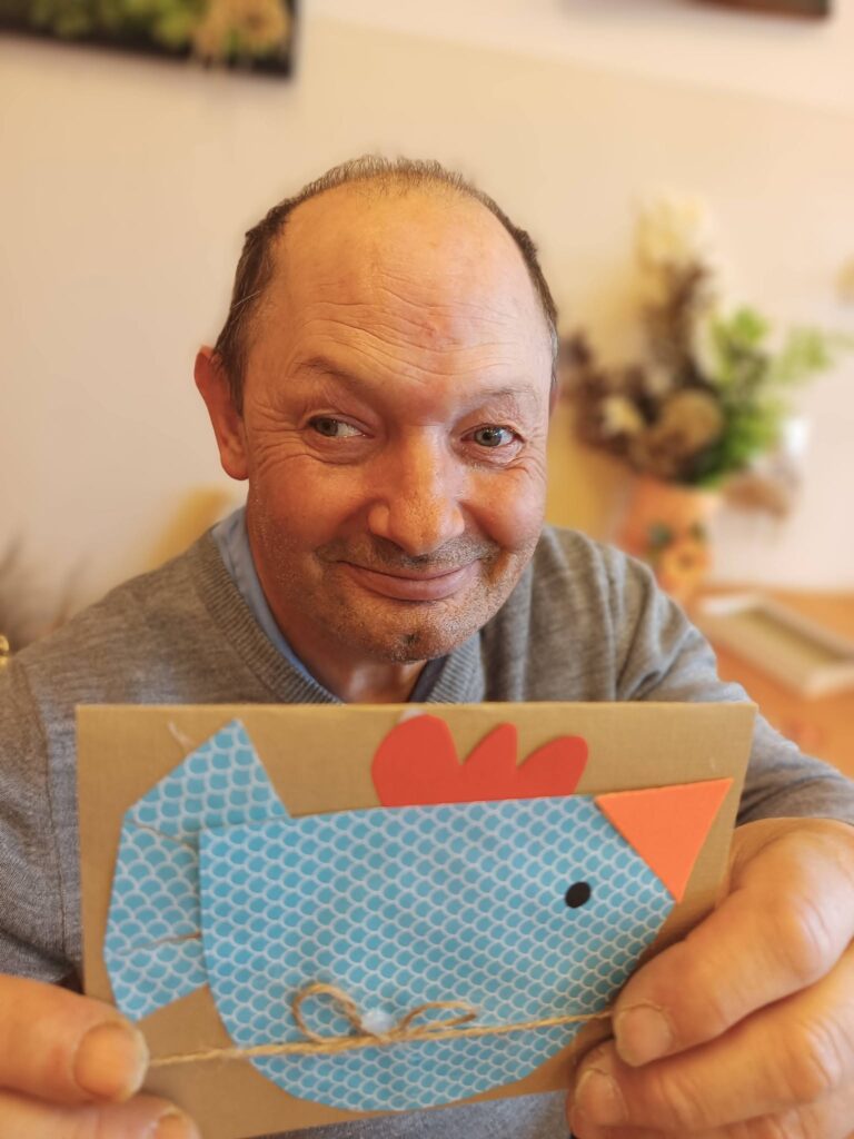 Podopieczny trzyma w ręce kartkę świąteczną