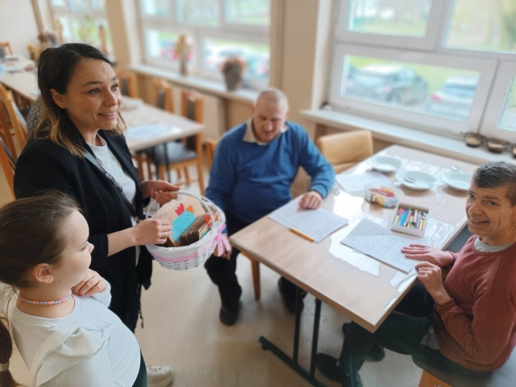 Pani nauczycielka rozdaje podopiecznym kartki świąteczne