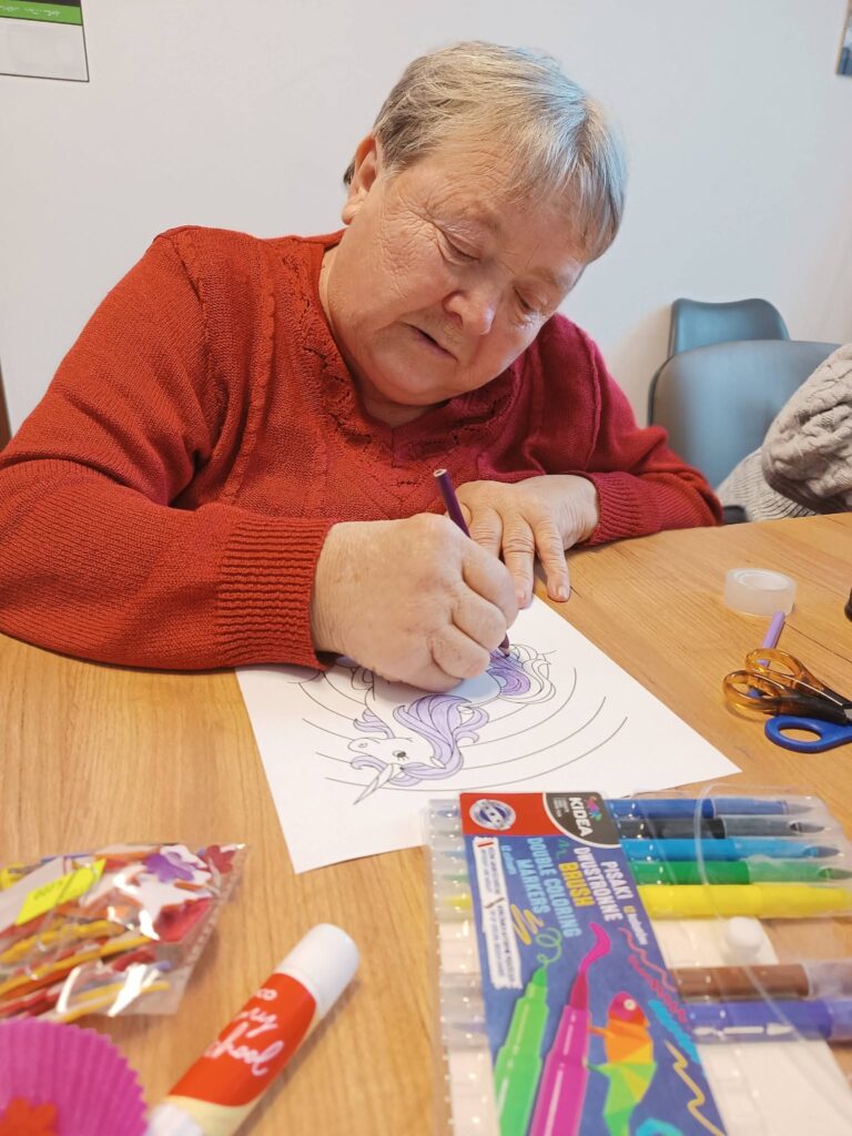 Podopieczna koloruje obrazek jednorożca