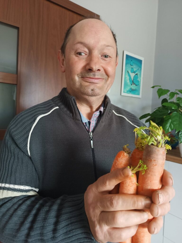 Podopieczny trzyma w rękach pęk marchwi