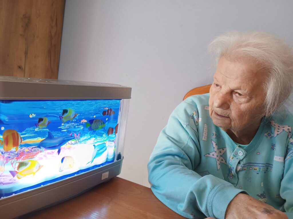 Podopieczna obserwuje lampę wodną z motywem oceanu
