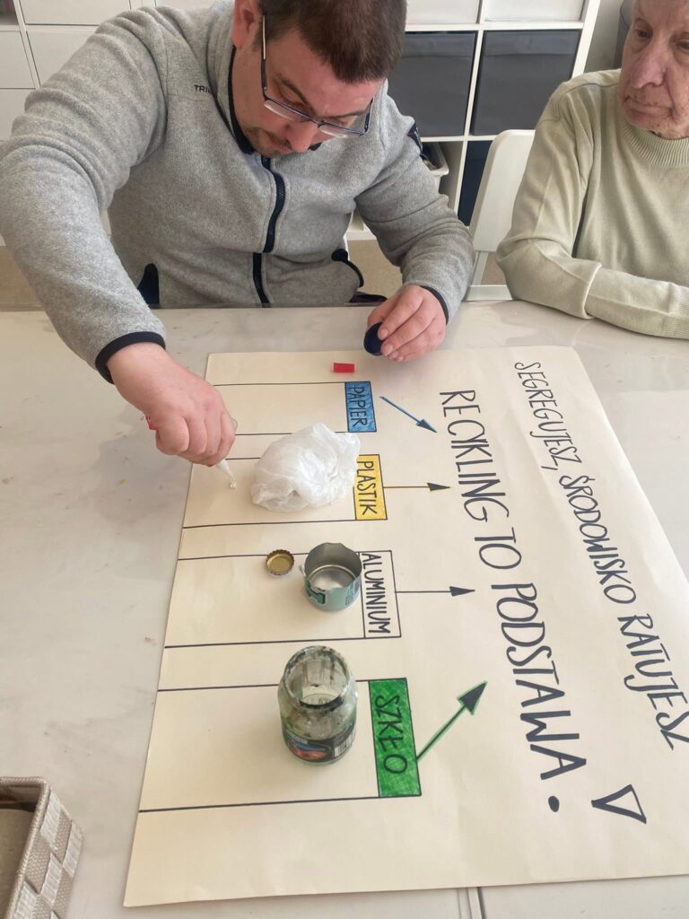 Podopieczni wykonują plakat o recyklingu