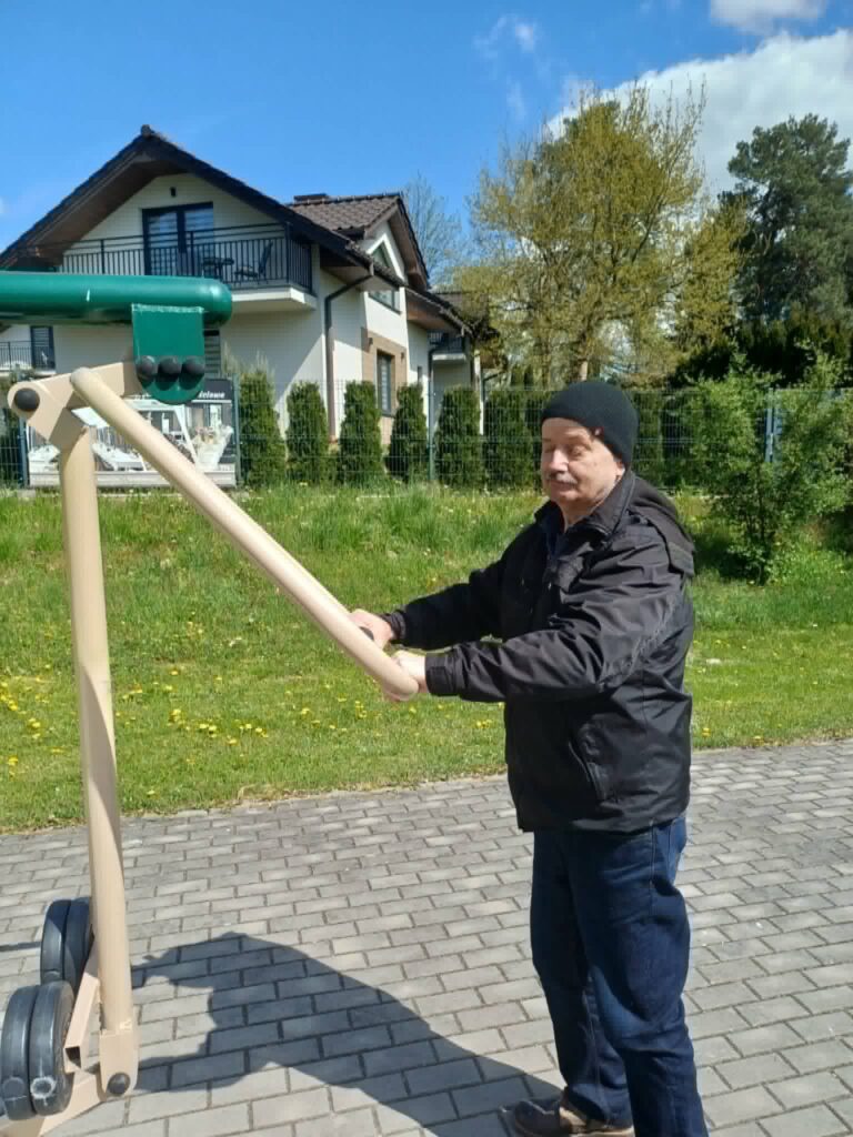 Podopieczny ćwiczy w siłowni pod chmurką