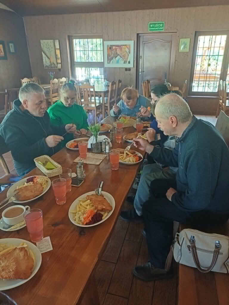 Grupa podopieczny je obiad w restauracji