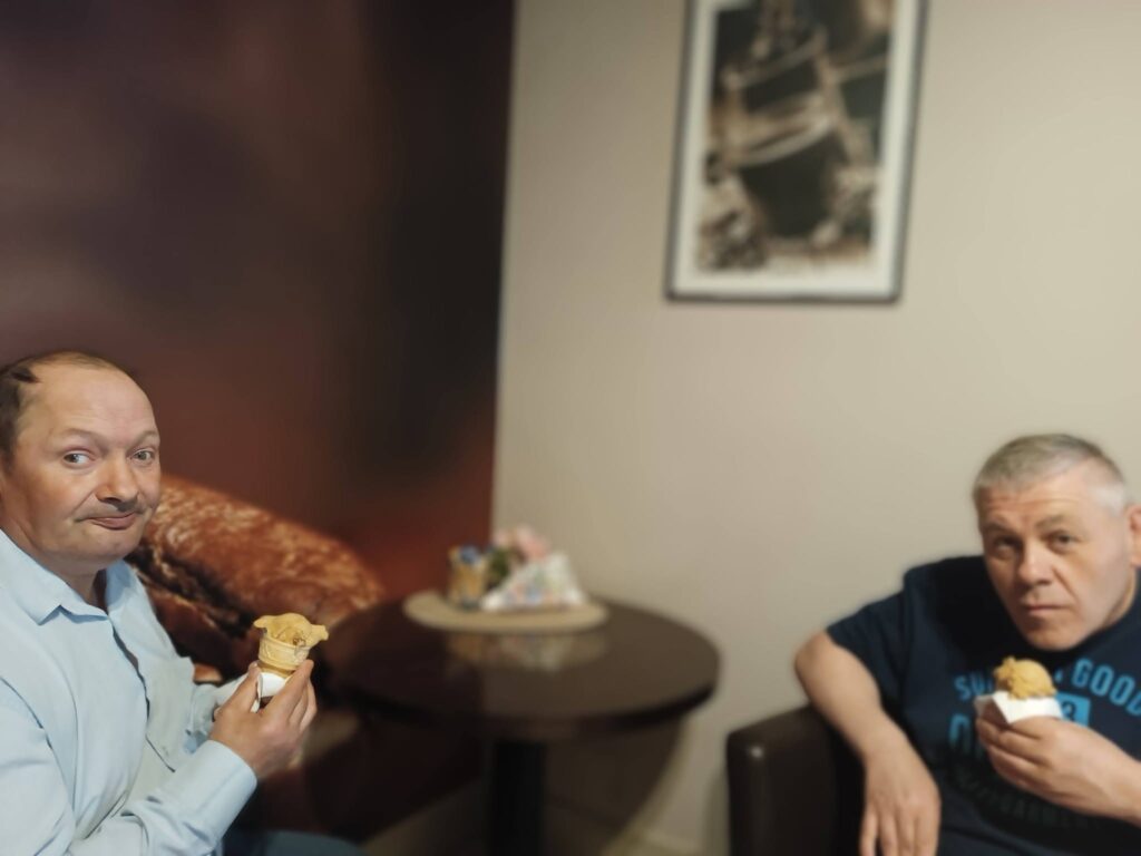 Podopieczni jedzą lody w kawiarni