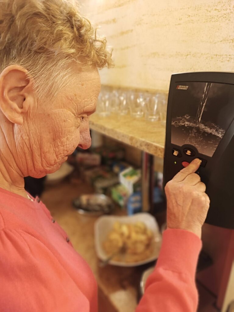 Podopieczna przygotowuje sobie napój w automacie