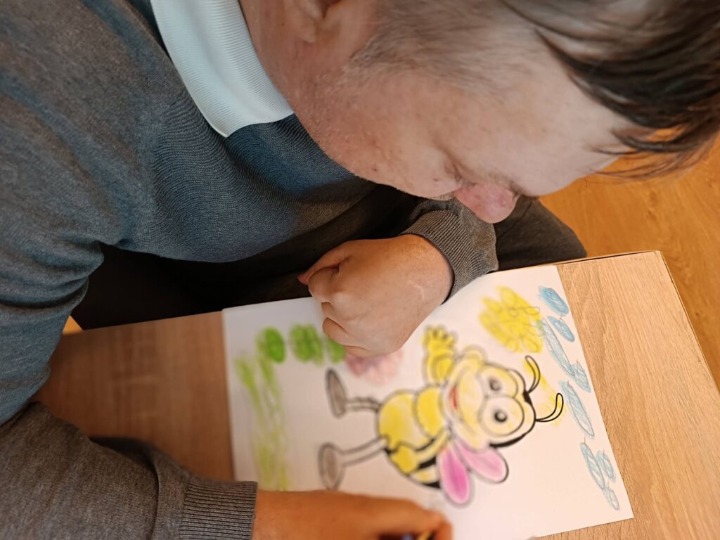 Podopieczny koloruje kredkami