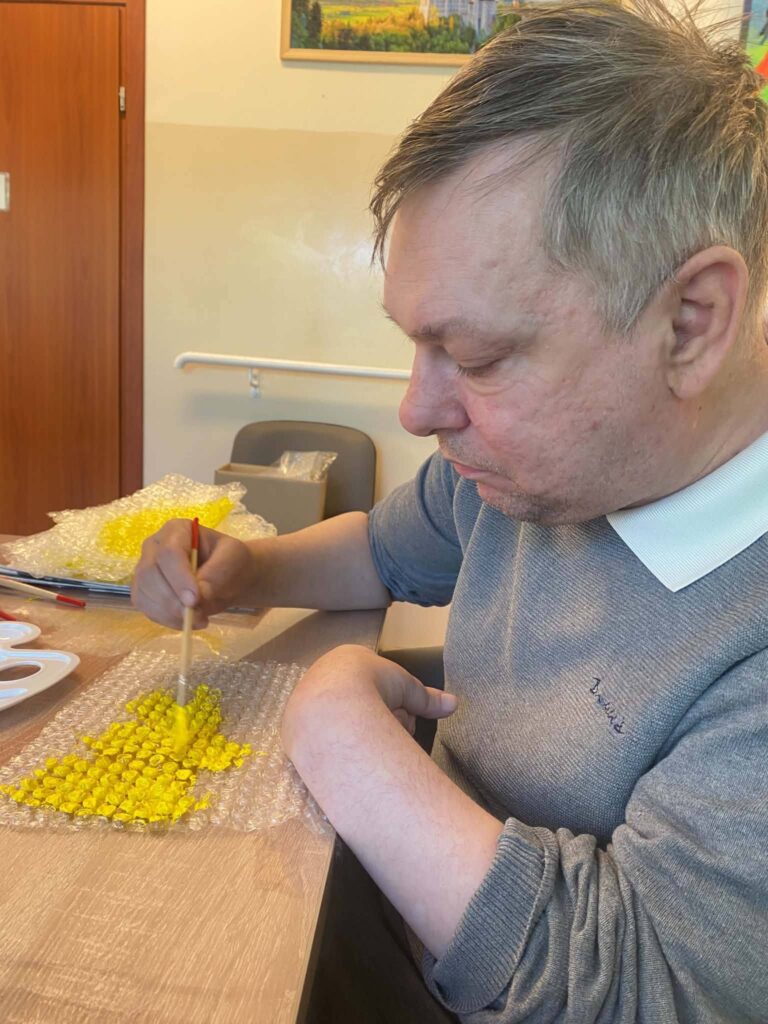 Podopieczny wykonuje pracę plastyczną w ramach dnia pszczelarza