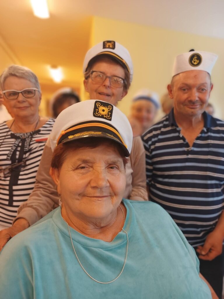 Podopieczni pozują do zdjęcia w kapitańskich czapkach