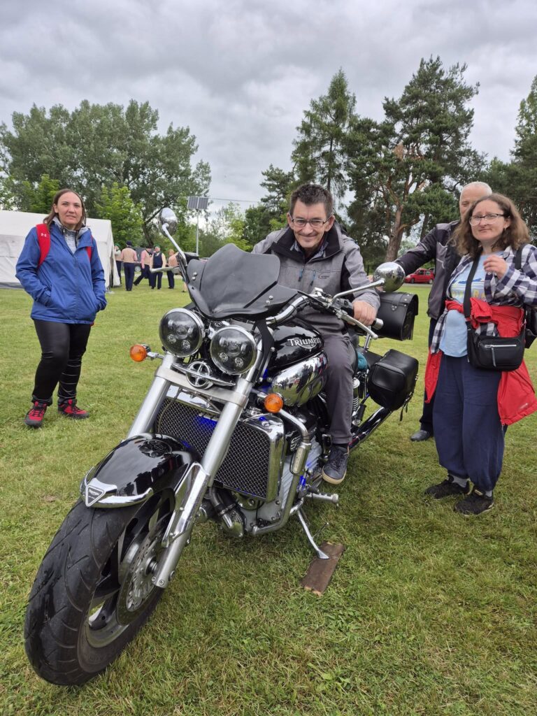 Podopieczni pozują przy motocyklu