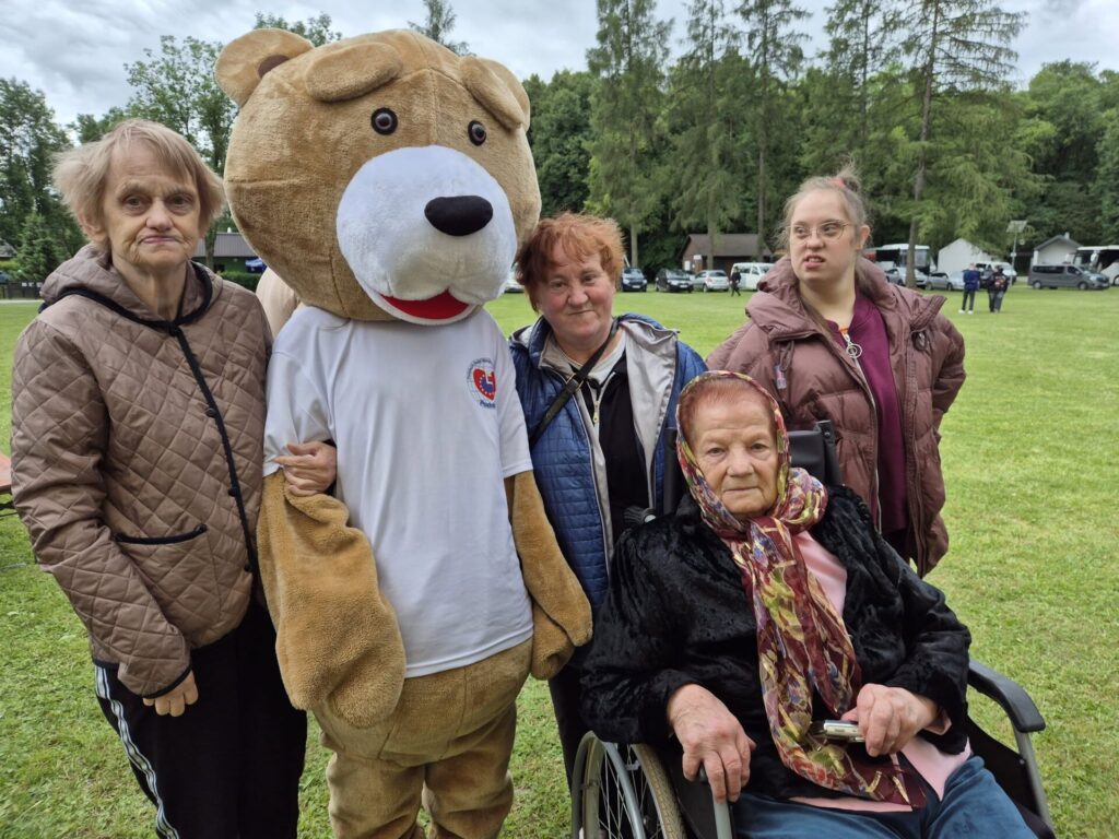 Podopieczni pozują do zdjęcia grupowego z żywą maskotką