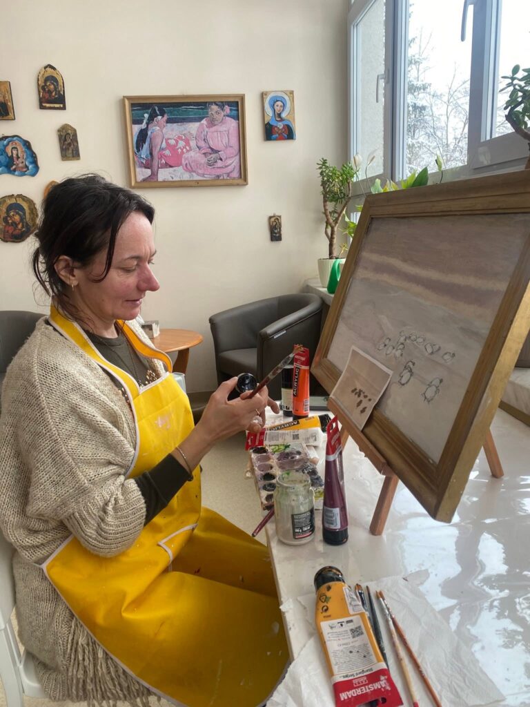 Podopieczna maluje obraz na konkurs artystyczny