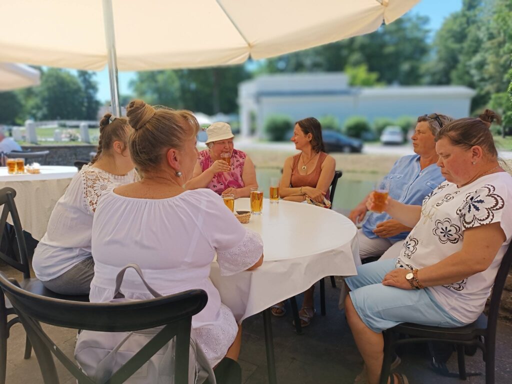 Grupa odpoczywa pod parasolem ogrodowym